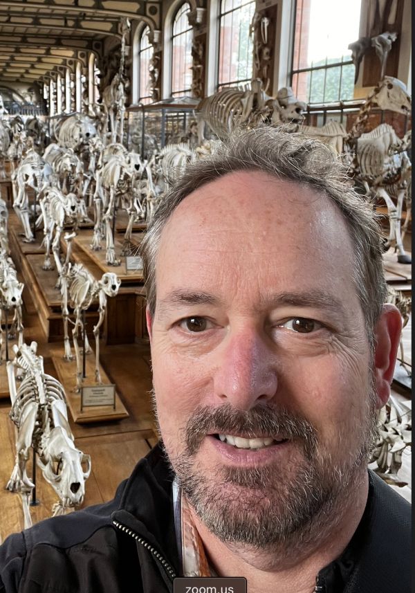 Professor standing in front of animal skeletons