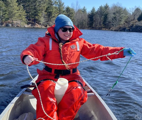 Erin in a boat on a lake conducting research