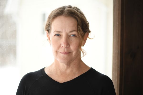 picture of a woman sitting in front of a window smiling. 