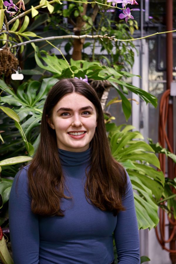 Kirsten sitting in front of plants