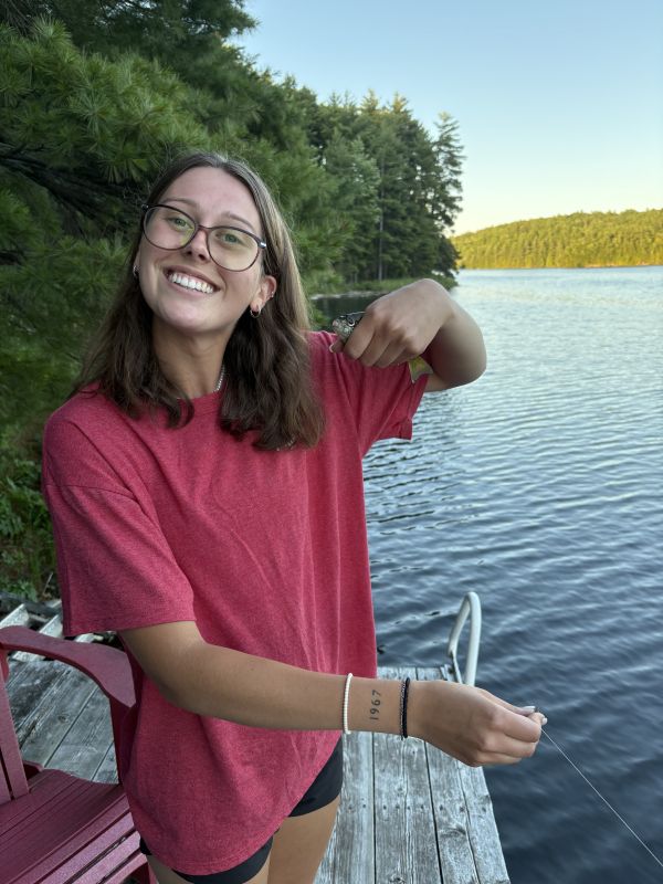 Kirsten on a dock with a small fish in her hand