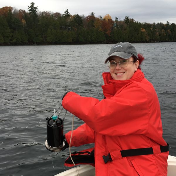 Krysten doing research in a boat on a lake