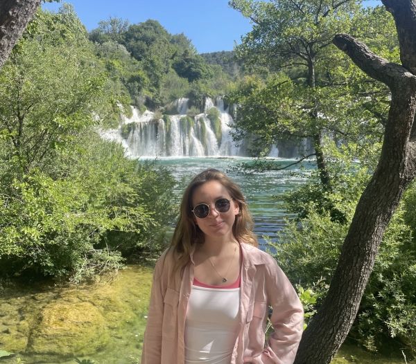 Maddigan in front of a waterfall and woods