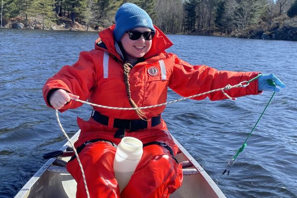 Erin in a boat on a lake conducting research