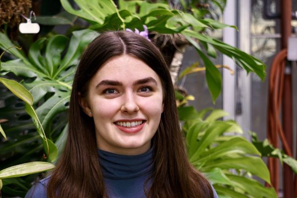 Kirsten sitting in front of plants