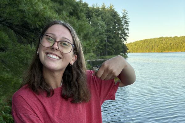 Kirsten on a dock with a small fish in her hand